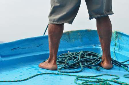 Fisherman at the bow of the boatの写真素材