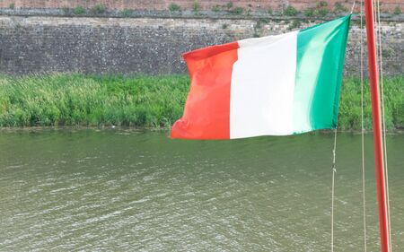 Italian flag against blue skyの写真素材