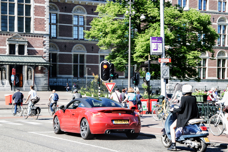 AMSTERDAM, NETHERLANDS - JUNE 03, 2017:  traffic stopped at a red light on the Damrak street in Amsterdamのeditorial素材