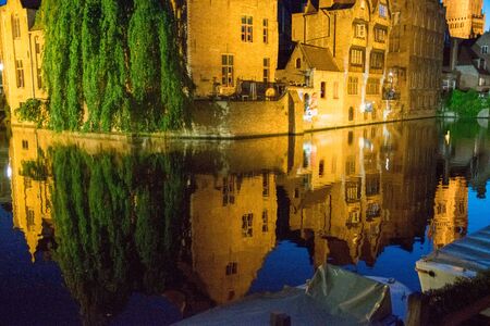 Night view of canal with reflection on water in Bruges, Belgiumの写真素材