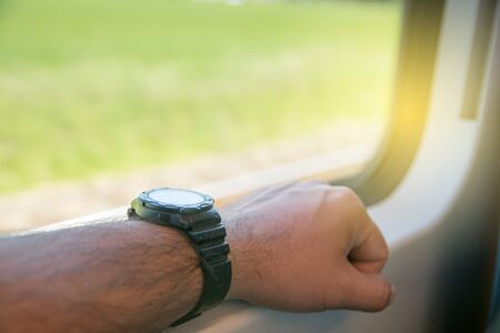 Hand with black watch leaning on train windowの写真素材