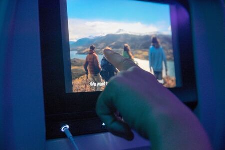 MADRID, SPAIN - JUNE 18, 2017:  Hand touching a digital screen during a travel in the airplaneのeditorial素材