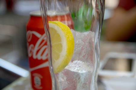 BARCELONA, SPAIN - JULY 18, 2017: Empty glass with ice cubes, lemon slice and coke canのeditorial素材
