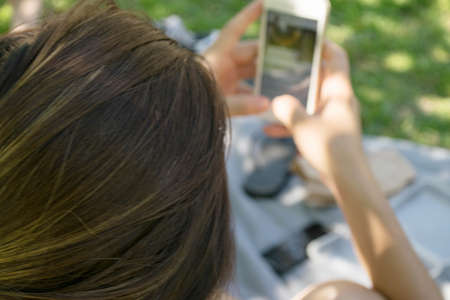 Beautiful young hipster woman using smart phone at parkの写真素材