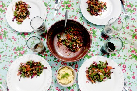 Table set for four with salad and colorful table clothの写真素材