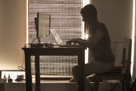 Woman typing on a laptop keywordの写真素材