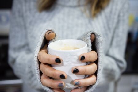 Close up of a woman holding hot coffee cup in winterの写真素材