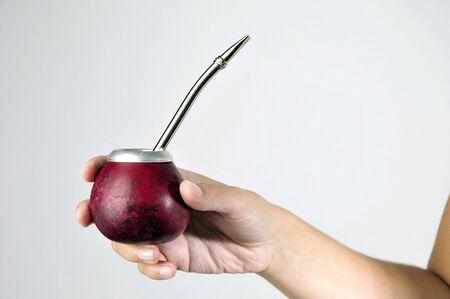 Hand and Yerba Mate drink on white backgroundの写真素材