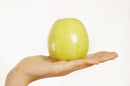Woman holding green apple in handの写真素材