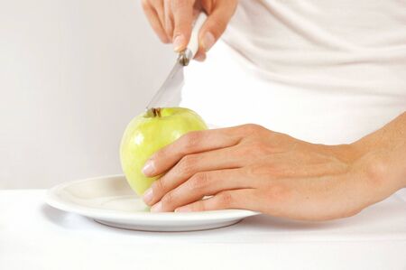 Woman holding green apple on plateの写真素材