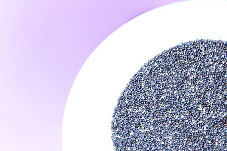 Chia seeds in a plate on a pink background. Flat layの写真素材