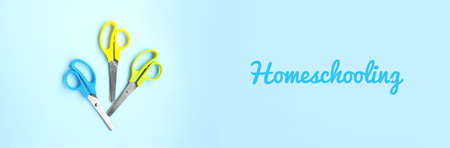 Set of blue, yellow and green scissors on a blue background with space for text. Banner. School...