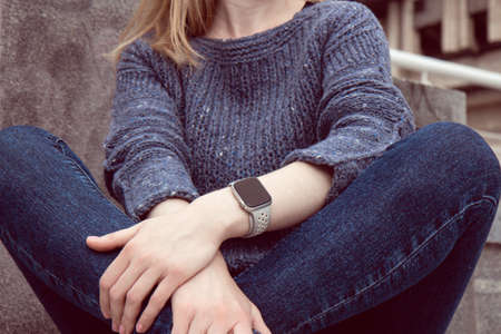 Young beautiful woman in a cozy blue sweater spends time outdoors. Lifestyle portrait of femaleの写真素材