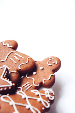 Tasty homemade Christmas gingerbread cookie of various shapes with sugar glaze on white background...