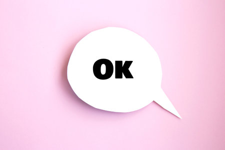 White paper speech bubble concept with inscription ok. Cartoon speech with bright backgroundの写真素材