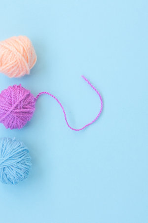 Three skeins of colorful woolen yarn in a row on a light blue background with copy space. Close upの写真素材