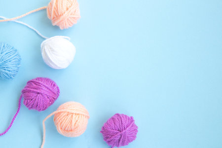 Several colorful skeins of thread on a light blue background with copy spaceの写真素材
