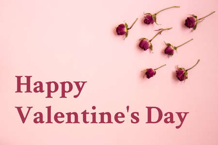 Valentines Day background. Miniature red rose buds on pastel pink background. Valentines day concept. Flat lay with copy spaceの写真素材