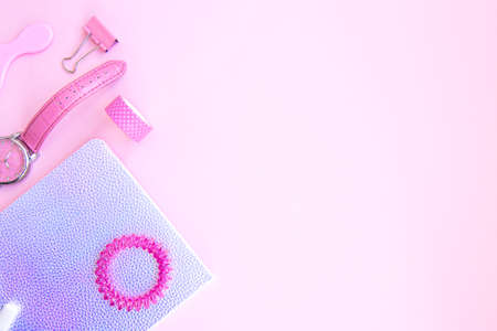 Pink set for girls. Neon notebook,  tape, watch, clips, chewing gum and hair tie on a pink...