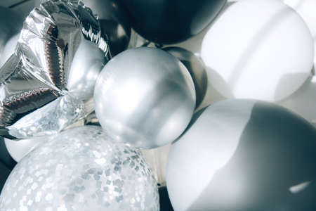 Background of white and gray balloons with shadows. Monochrome abstract background. Various party balloonsの写真素材