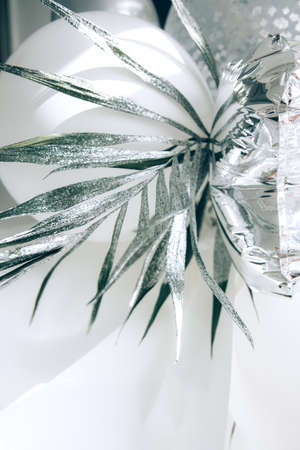 Beautiful white abstract background with folds and bends of paper with a green branch in a bright light. Draped background. Copy spaceの写真素材