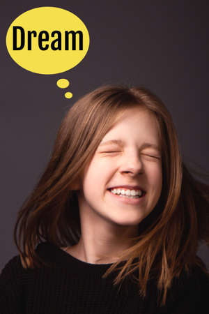 Beautiful smiling girl with long hair on a dark backgroundの写真素材