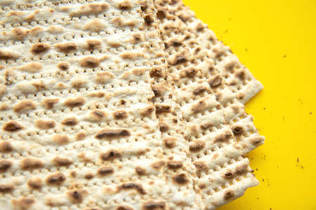 Traditional Jewish kosher matzo for Passover. Set with Passover matzos on yellow background. Pesach...