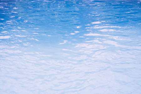 Surface of blue swimming pool. Background of blue ripped water in swimming poolの写真素材