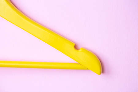 One wooden yellow clothes hanger on a bright pink background. Creative flat lay with copy space. Shopping conceptの写真素材
