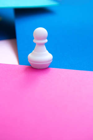 White chess figure on a bright colorful background. One chess pawn on a bright background. Abstract backgroundの写真素材