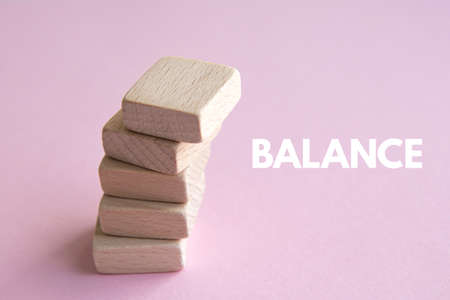 Stack of wooden cubes on a pink background. Balance conceptの写真素材