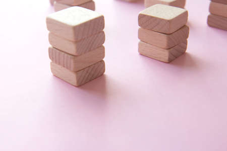 Set of stacks of wooden cubes on a pink background. Concept of team building, teamworkの写真素材