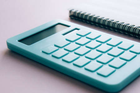 Mint calculator and notebook isolated on pink background. Concept of family budget and payment of taxes, investmentsの写真素材