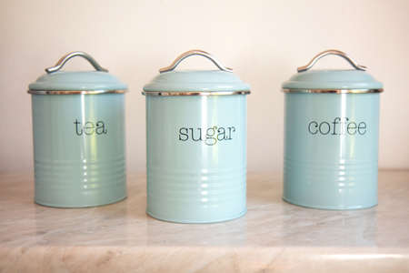 Three blank round iron kitchen containers on light background, containers label mockup. Close up