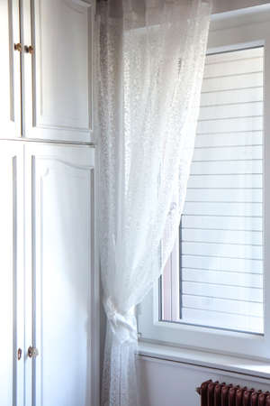 White bedroom interior. Soft light from the window illuminates the white wardrobe.の写真素材