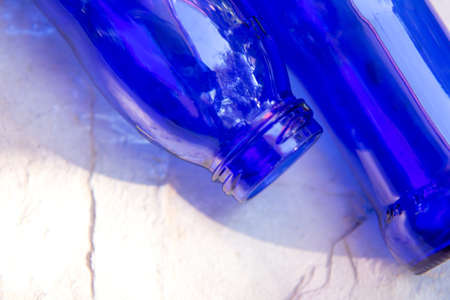 Blue glass bottles on light wooden backgroundの写真素材