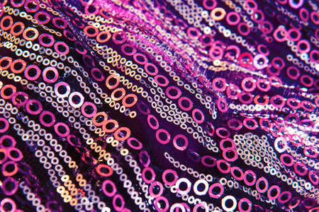 Beautiful pink bright shiny fabric with sequins and glitter with shiny beads. Draped background of...