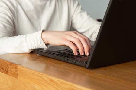 Woman working on a laptop at her workplace. close up