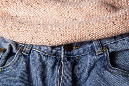 Light pink soft, fluffy, light textile with shiny sequins and classic blue jeans. Texture white cotton textile backgroundの写真素材