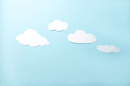 paper art. White clouds on a bright blue background. flat layの写真素材