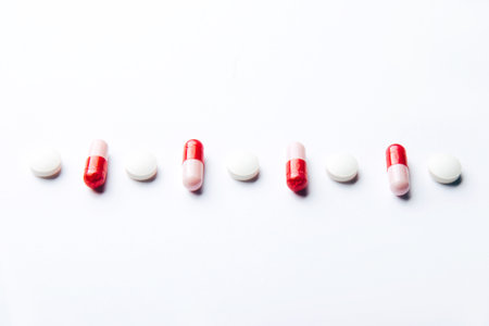 Pink vitamin tablets on a white background. dietary supplements and pills for dieting. medical concept. Seen from above. flat layの写真素材