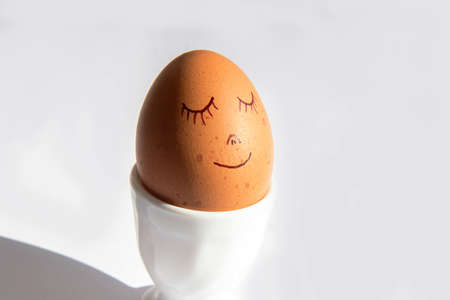 Easter holiday concept with cute handmade egg in egg stand on white backgroundの写真素材