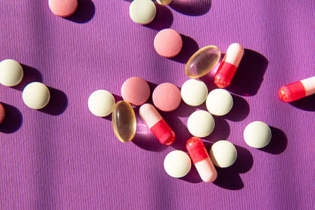 Vitamin tablets on a violet background. Dietary supplements and pills for dietingの写真素材