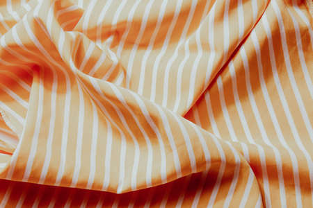 Beautiful yellow fabric with white stripes background. Draped background of fabric, textureの写真素材