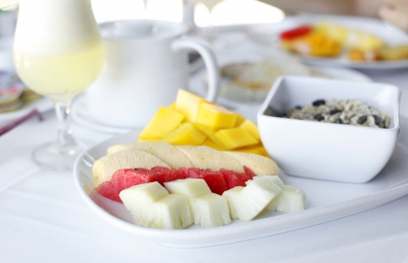 healhty breakfast with assortment of fresh fruits, cereal muesli and fresh pineapple juiceの写真素材