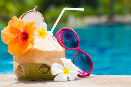 exotic fresh coconut shake and sunglasses by the tropical poolの写真素材