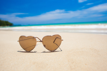 heart shaped sunglasses hat on tropical beachの写真素材