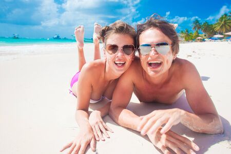 portrait of happy young couple with suncream dots at beacの写真素材