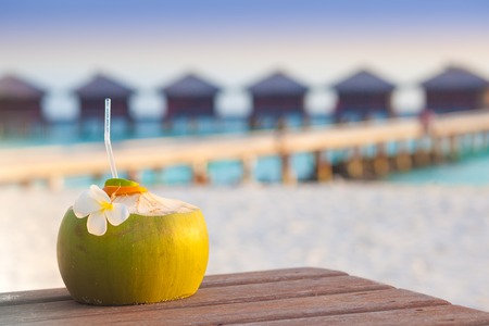 Fresh coconut cocktail on a tropical beach. eveningの写真素材