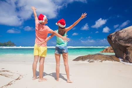 young couple in santa hats having fun on tropical beach. new year, Seychellesの写真素材